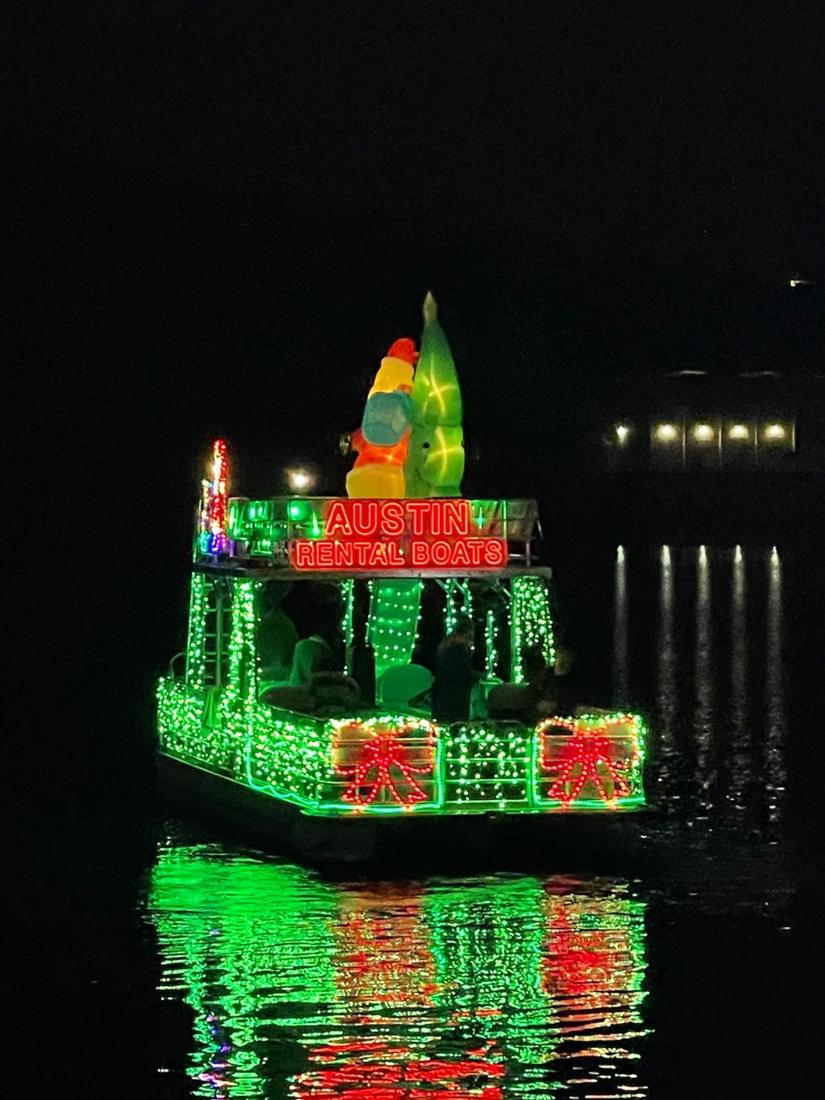 A boat under holiday lights on Lake Austin