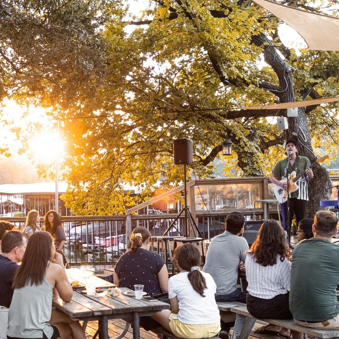 A singer performing on the deck at golden hour